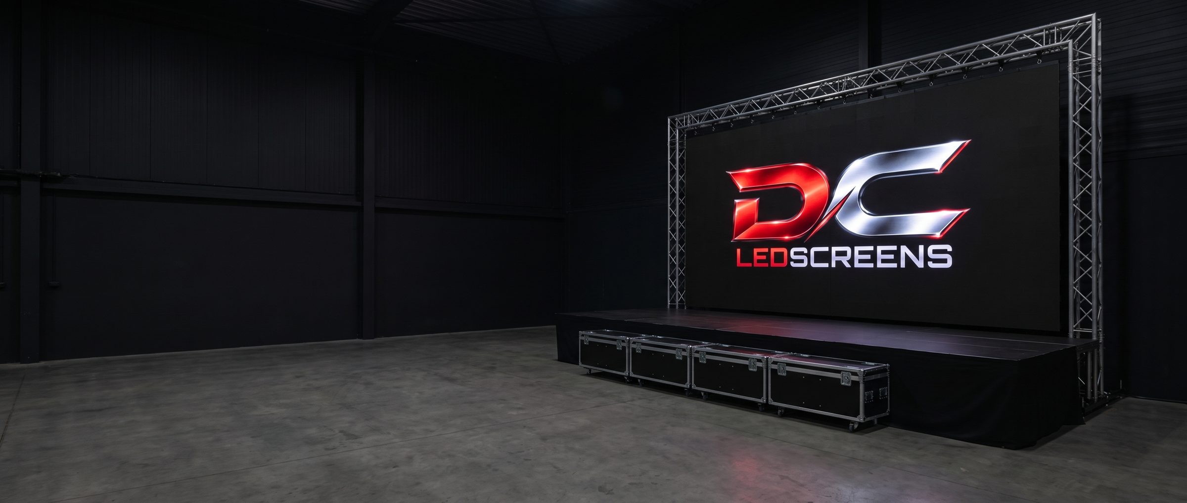 LED-wand aan een truss op een podium in een lege hal, op het scherm staat het logo van DC LedScreens