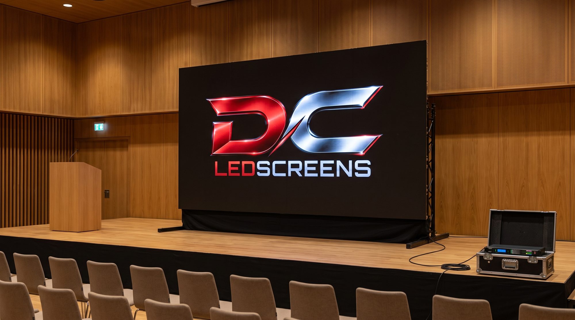 LED-wand op het podium van een lege congreszaal, stoelen in rijen