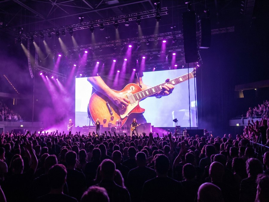 Groot LED-scherm achter een band bij een concert in een arena