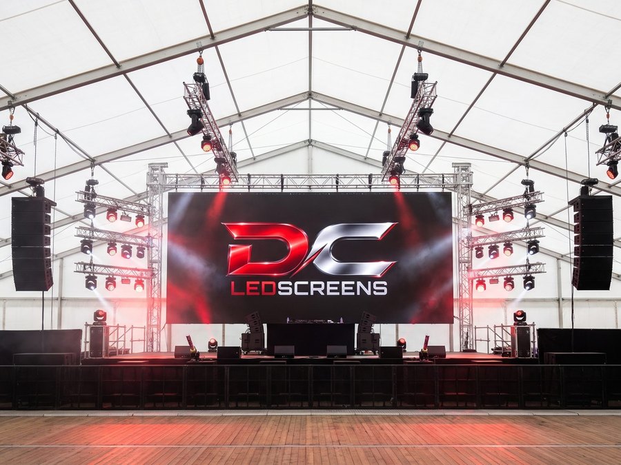 LED-wand op een podium in een tent, met licht en geluid ernaast